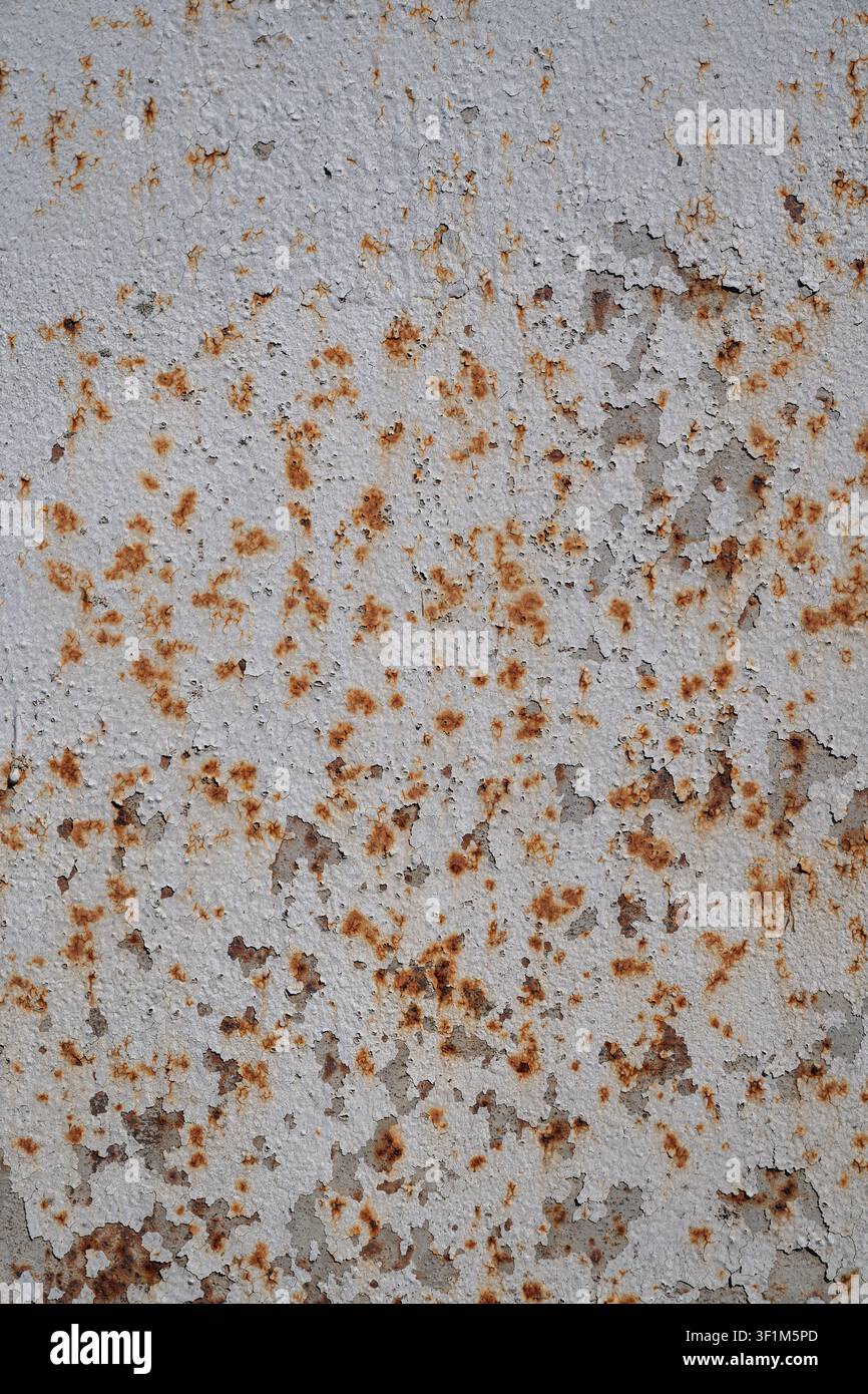 Prima verticale di una superficie metallica antica con vernice grigia scrostata e macchie di ruggine Foto Stock