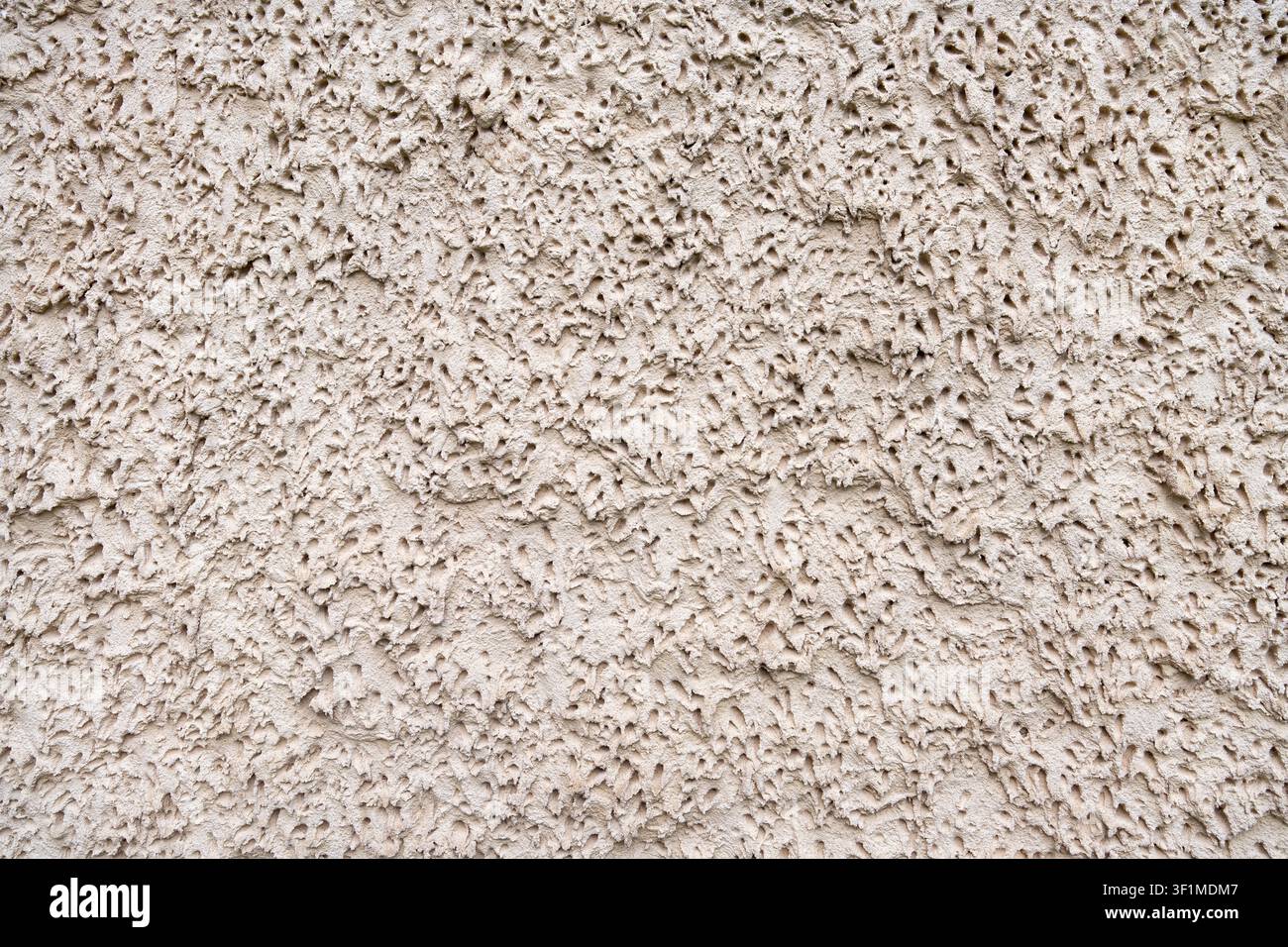 Intonaco a texture molto grossa, beige, astratto, su un muro Foto Stock