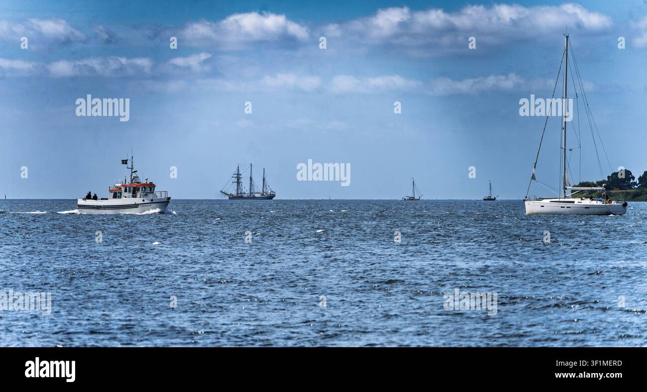 Scena marittima serena con navi da diporto e da commercio sotto una morbida luce mattutina Foto Stock