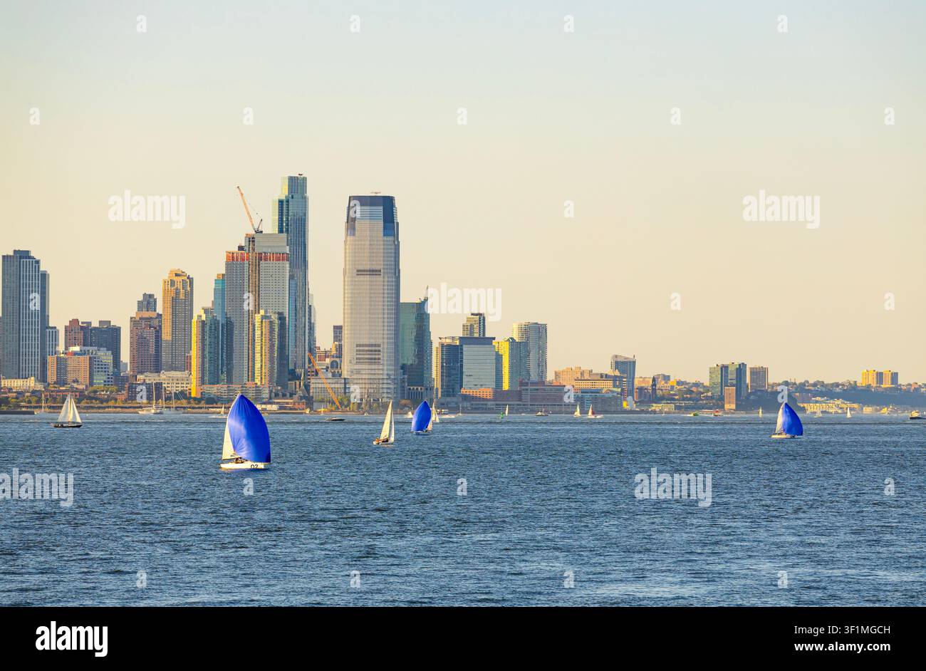 New York, USA - 25 agosto 2026: yacht a vela che navigano sulla baia di Hudson con i grattacieli di New York City sullo sfondo Foto Stock