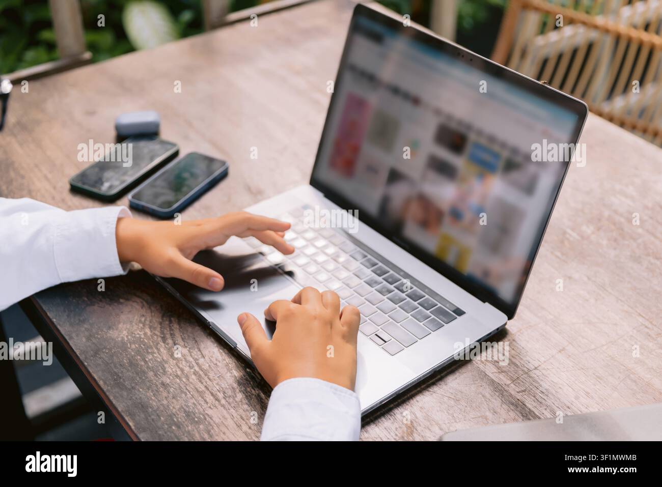 Prima di mani che utilizzano un computer portatile per lavori online all'aperto Foto Stock