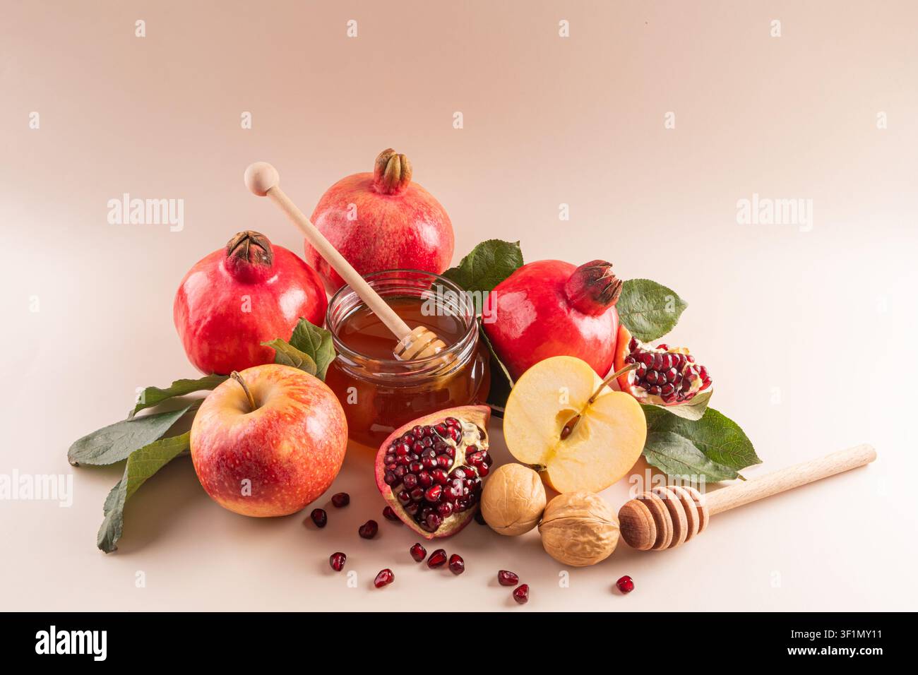 Una bellissima composizione di simboli tradizionali di Rosh Hashanah tra cui mele, melagrane, miele e noci, che rappresentano dolcezza, abbondanza, un Foto Stock
