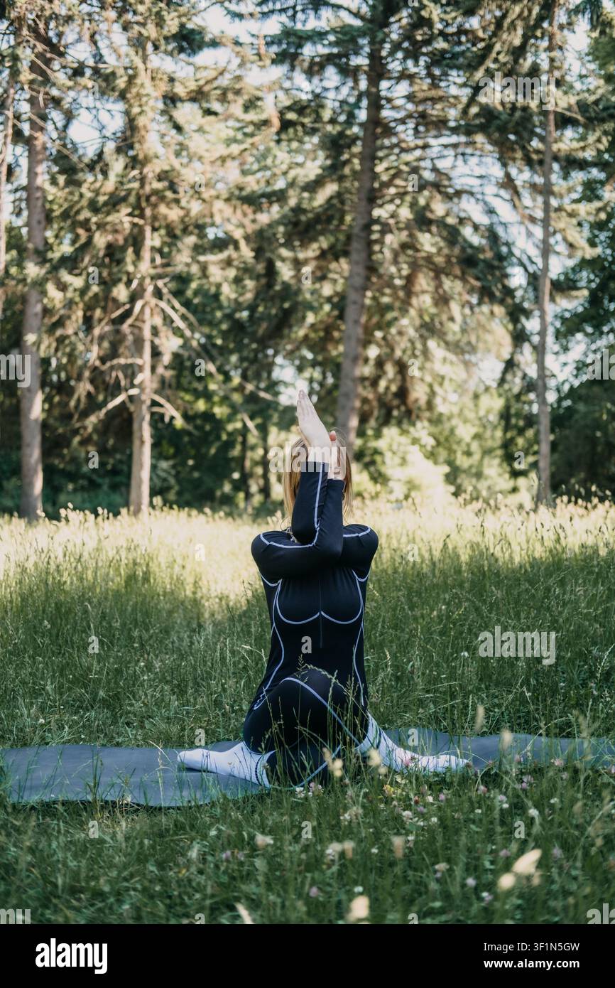 Donna in posa da yoga su materassino all'aperto, forza e flessibilità, viaggio di crescita personale, fitness all'aperto, movimento consapevole Foto Stock