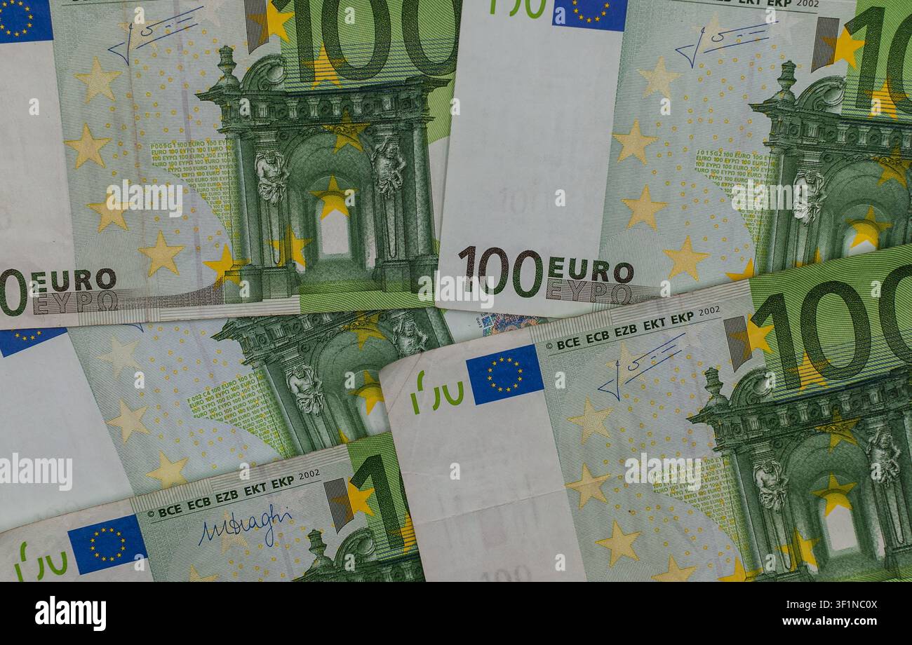 Una vista dettagliata dall'alto di diverse banconote da 100 euro verdi che si sovrappongono nel quadro. Foto Stock