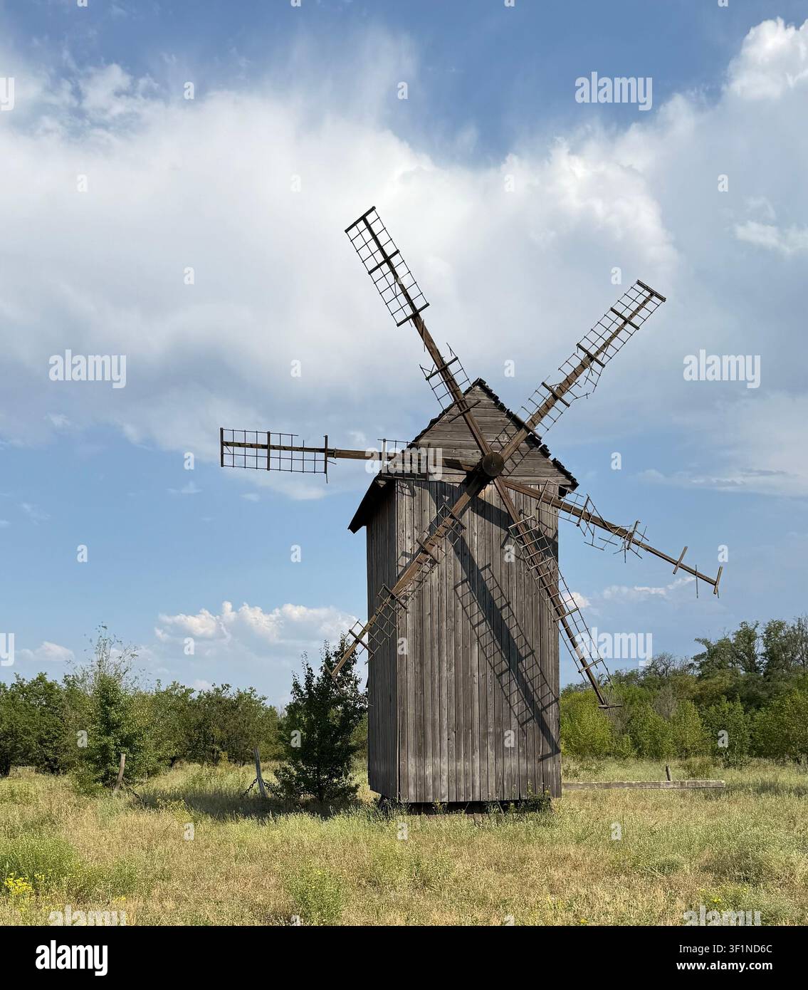 Vecchio mulino a vento in legno rustico in un campo di prato estivo. - Immagine stock catturata con smartphone