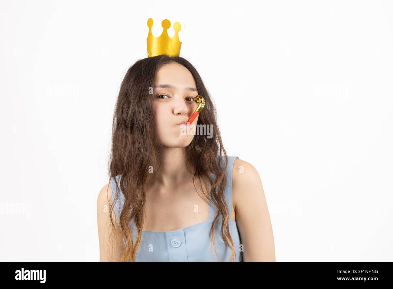 Donna elegante che indossa una piccola corona per una celebrazione in studio Foto Stock