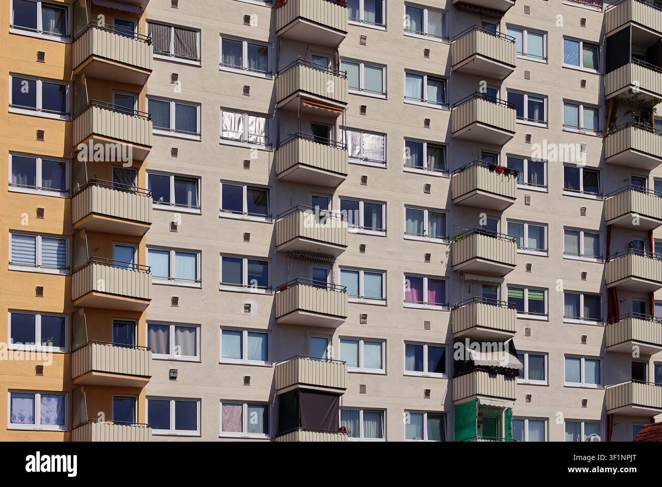 Facciata di edificio residenziale moderno con balconi e finestre ripetitivi in un quartiere urbano Foto Stock