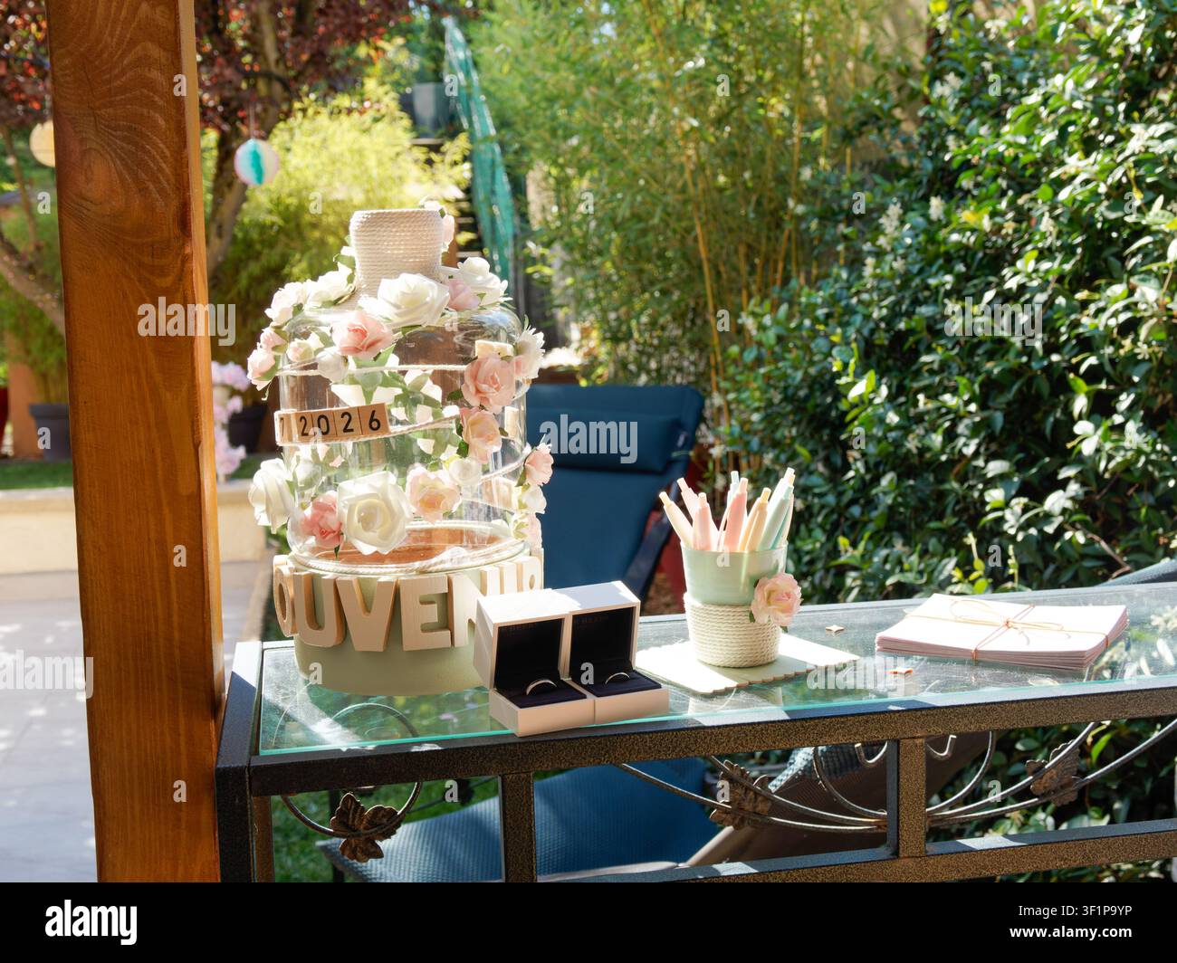 Tavolo per il libro degli ospiti del matrimonio con decorazione floreale e matite colorate in una reception in giardino Foto Stock