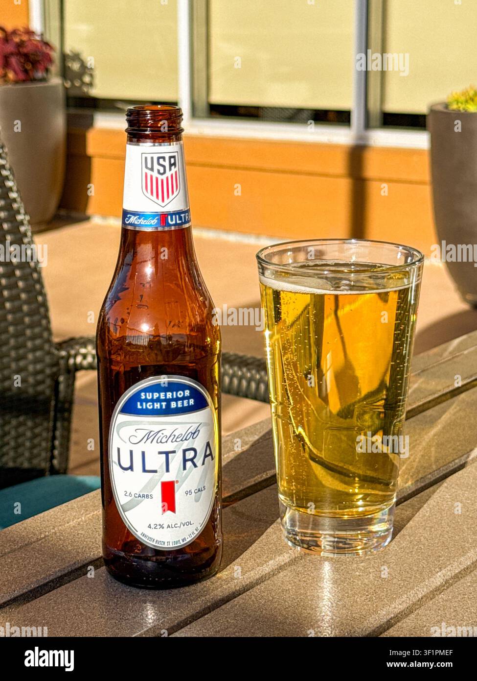 Page, Arizona, USA - 30 giugno 2026: Bottiglia di birra leggera Michelob Ultra e un bicchiere pieno su un tavolo sulla terrazza di un hotel. - Immagine stock catturata con smartphone