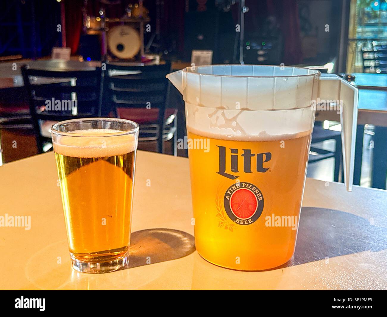 Las Vegas, Nevada, USA - 3 luglio 2026: Krug di birra bionda pilsner Miller su un tavolo in un bar con un bicchiere pieno di birra. - Immagine stock catturata con smartphone