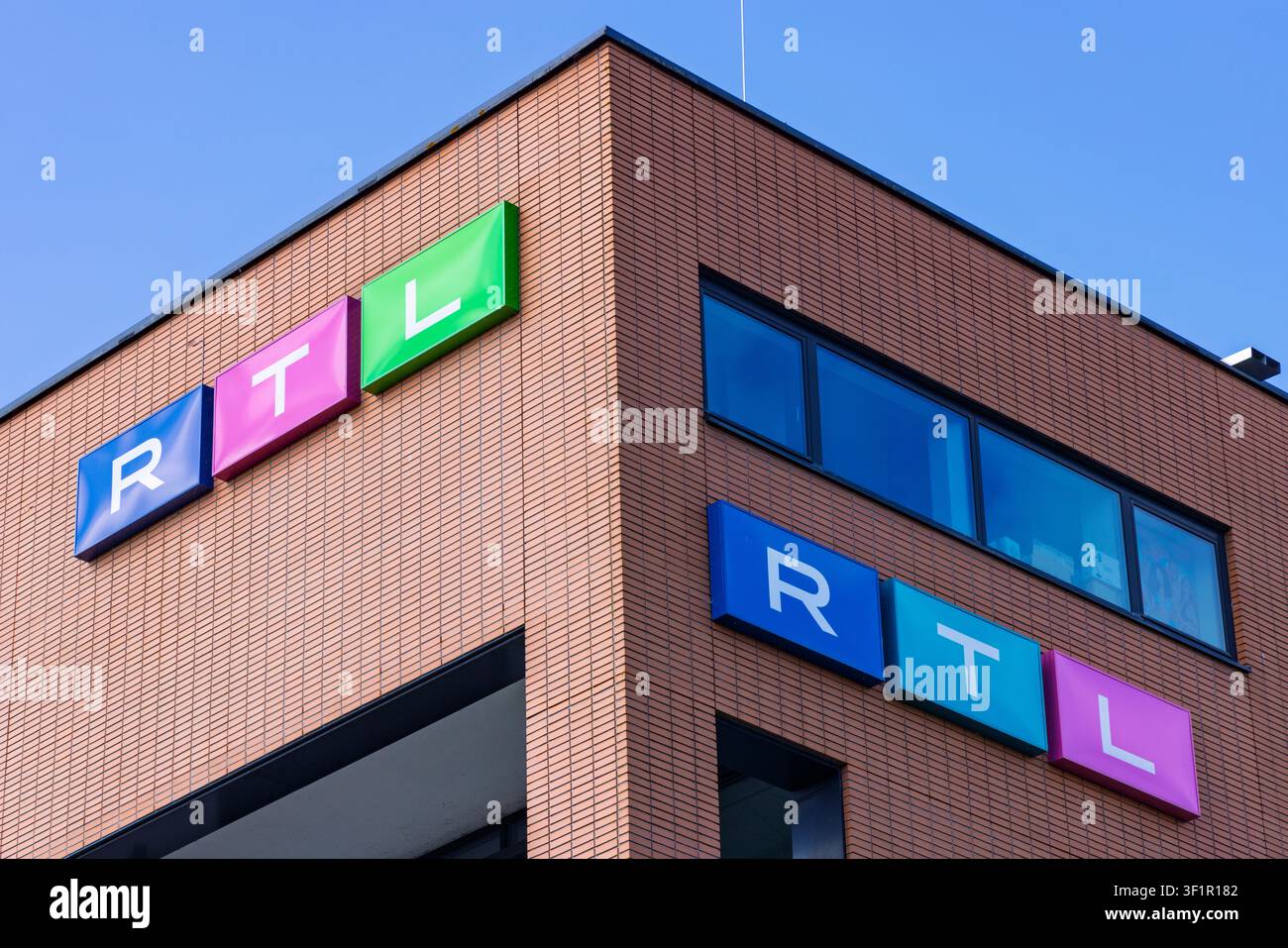 Hilversum, Paesi Bassi, 13 luglio 2026. Ripresa a bassa angolazione dei segnali colorati del logo RTL montati sull'angolo in mattoni del loro edificio uffici alla Media Foto Stock