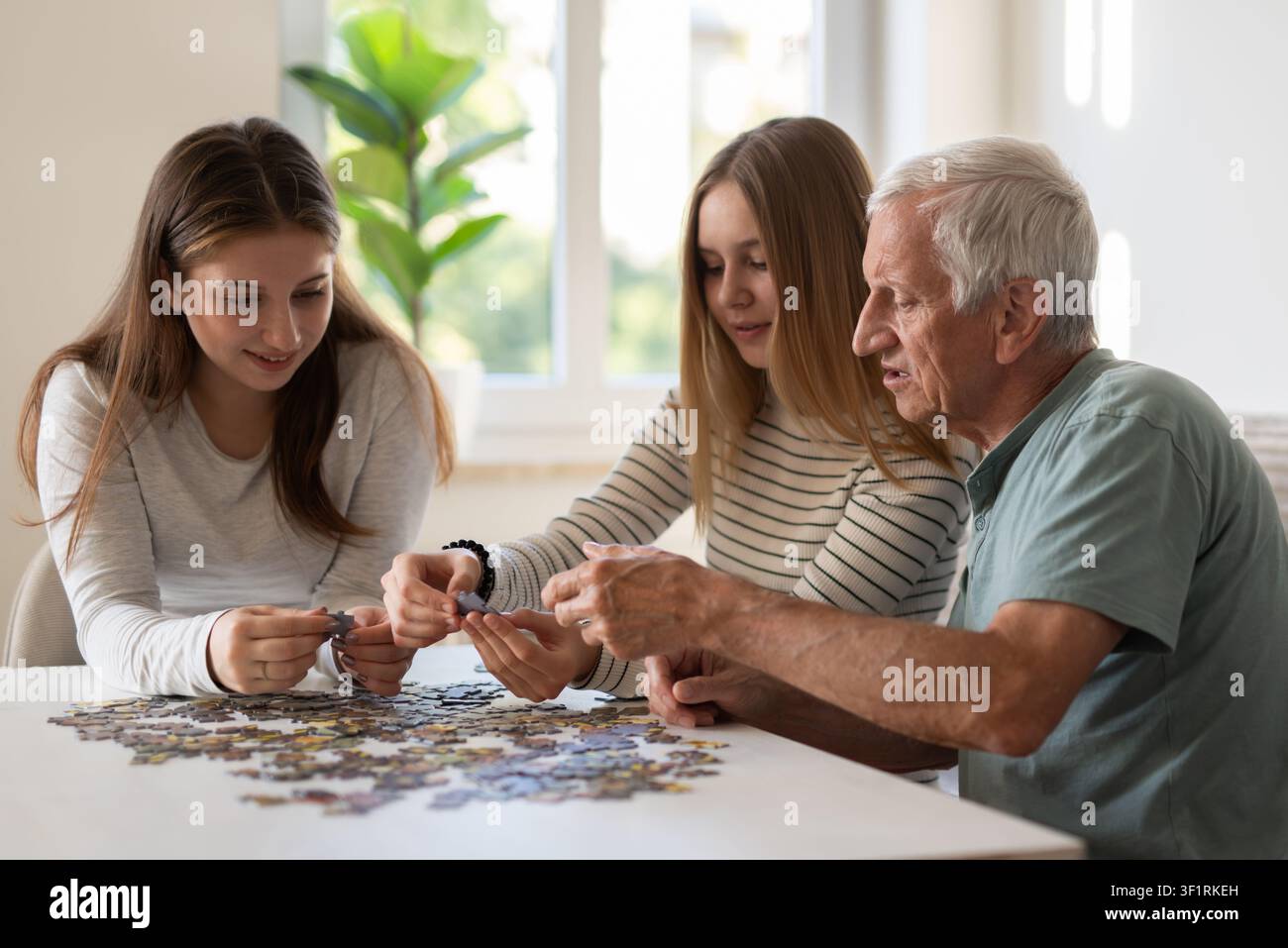 Famiglia che collega pezzi di puzzle e puzzle jigsaw e giochi da tavolo per casa Foto Stock