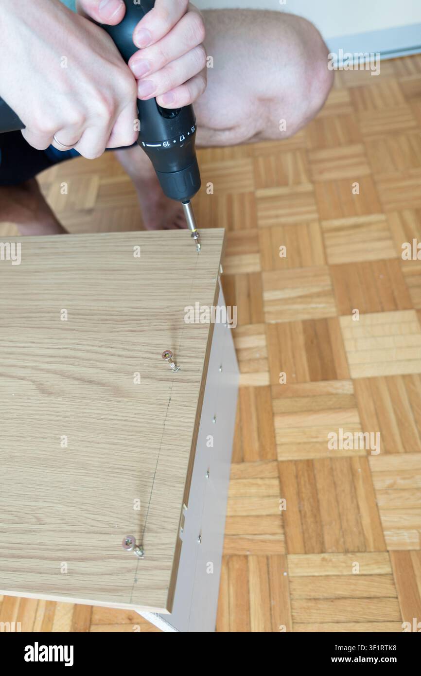 Vista aerea della viteatura di una vite in un pannello di legno per il montaggio di mobili flat pack Foto Stock