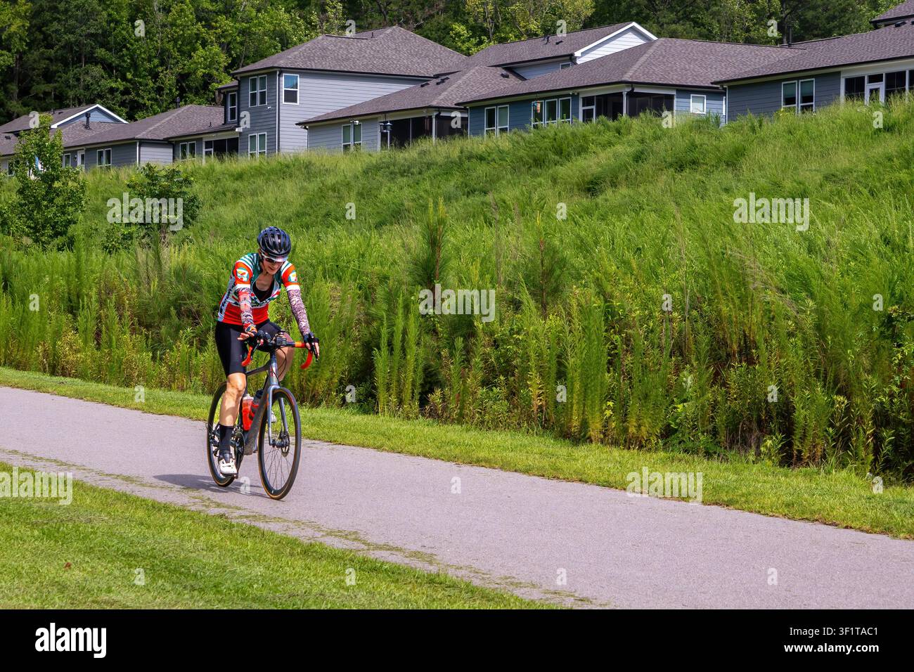 Clayton, NC, USA – luglio 2026: Ciclista in sella al Neuse River Trail vicino a Carolina Overlook, una comunità Del Webb. Foto Stock