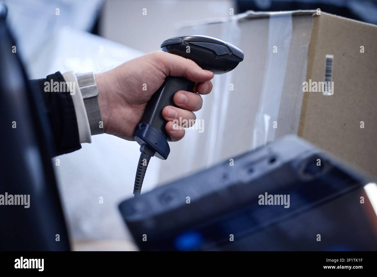 Uomo adulto che scansiona il codice a barre di una scatola di archiviazione per la gestione dell'inventario Foto Stock