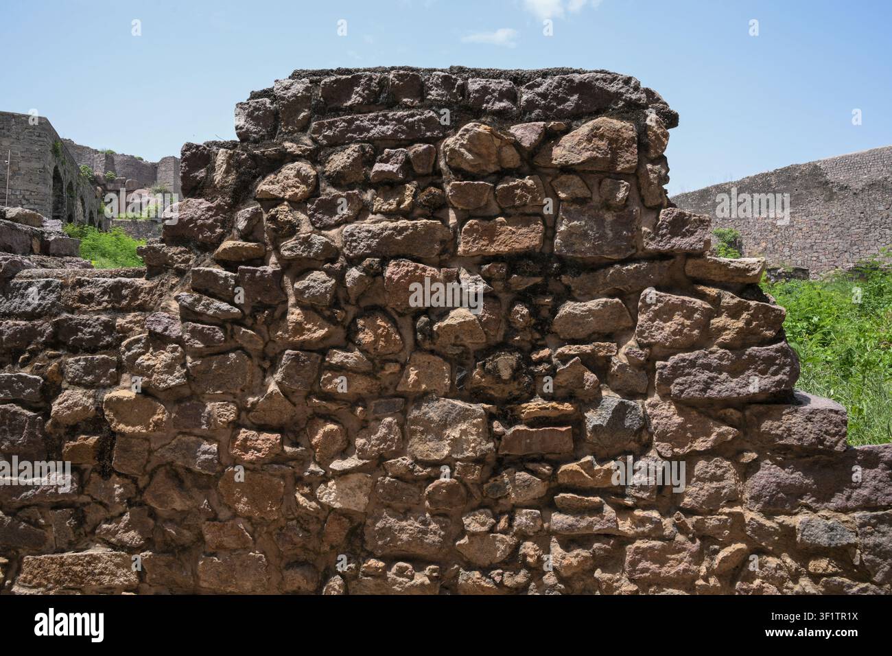 Texture di muro in muratura di pietra erosa dalle rovine di un'antica fortezza Foto Stock