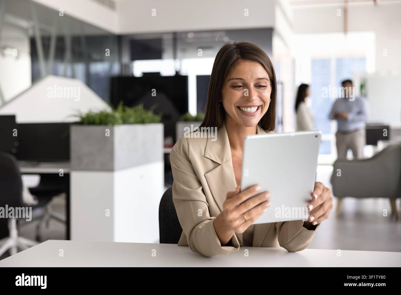 Donna d'affari che legge buone notizie in un'email utilizzando un tablet digitale Foto Stock