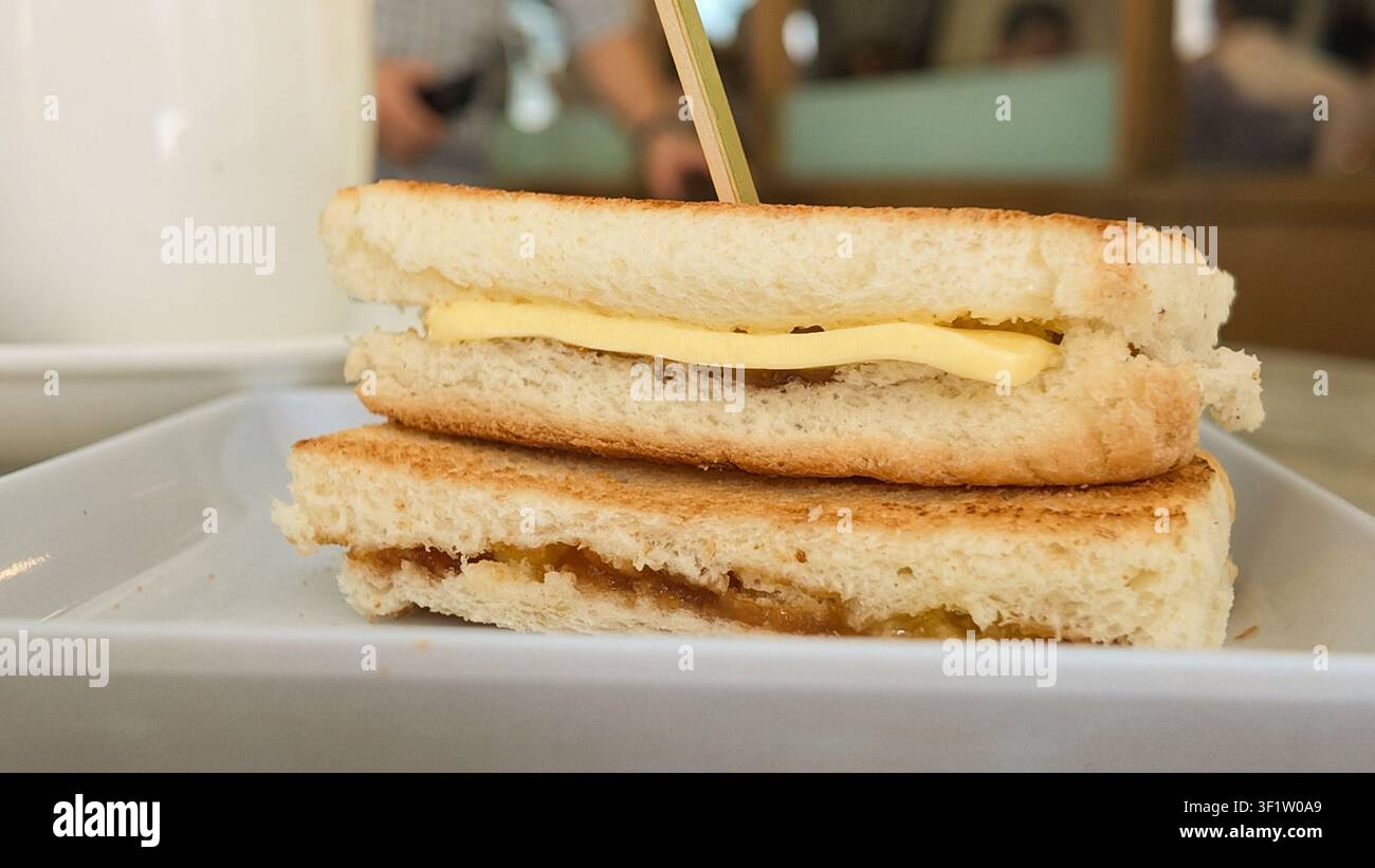 Colazione singaporiana conosciuta come Kaya Toast, servita su un piatto bianco Foto Stock
