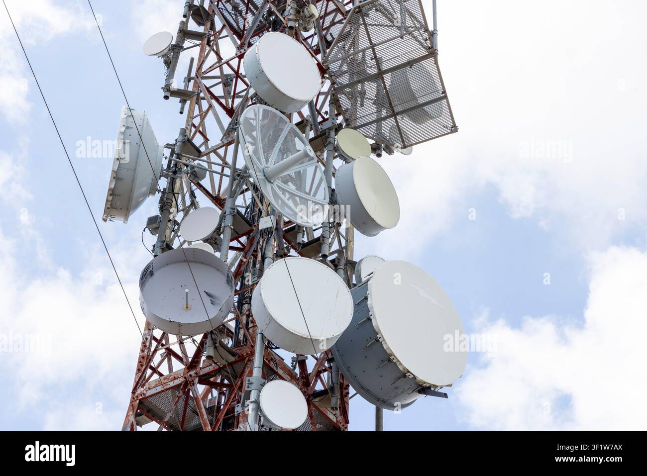 Torre di telecomunicazione con più parabole a microonde e antenne cellulari che trasmettono segnali per le reti di comunicazione e dati globali Foto Stock