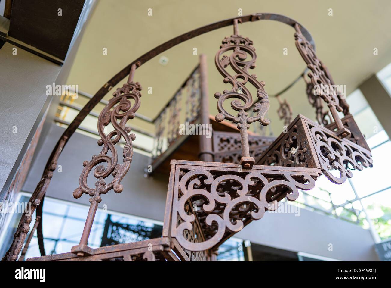 Scalinata a spirale in ferro metallico all'interno vicino al muro, primo piano. Scala circolare retrò come decorazione nell'interior Foto Stock