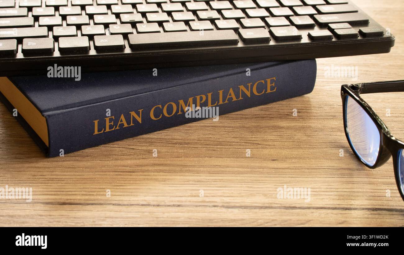 Dorso del libro Lean Compliance con tastiera del computer e occhiali Foto Stock