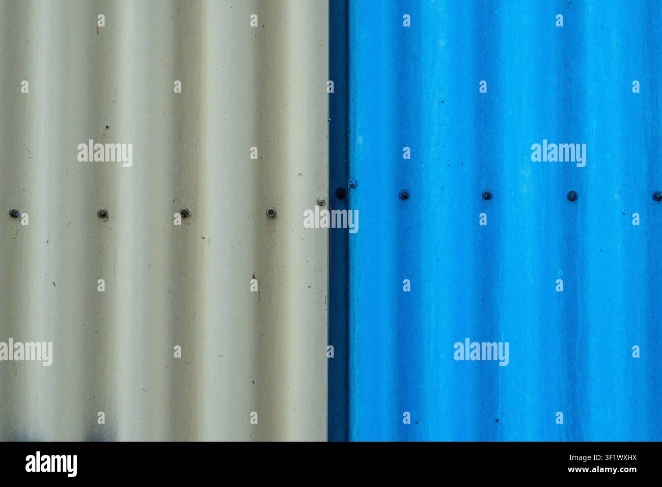 Texture minimalista di un muro in lamiera ondulata blu e beige Foto Stock