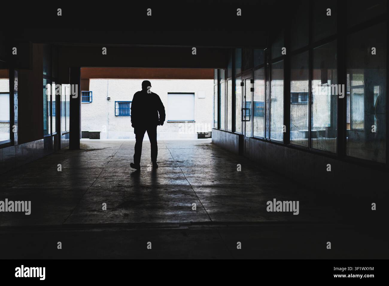 Silhouette di persona che cammina nel corridoio scuro Foto Stock