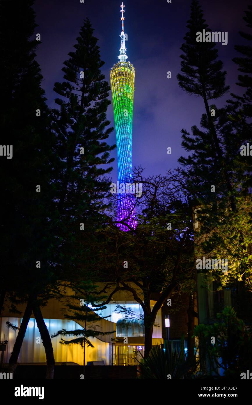 Un alto edificio illuminato nei colori dell'arcobaleno di notte a Guangzhou, Guangdong, Cina. Foto Stock