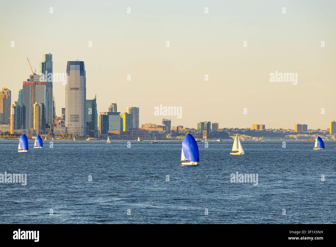 New York, USA - 02.09.2026: yacht a vela che navigano sulla baia di Hudson con i grattacieli di New York City sullo sfondo Foto Stock