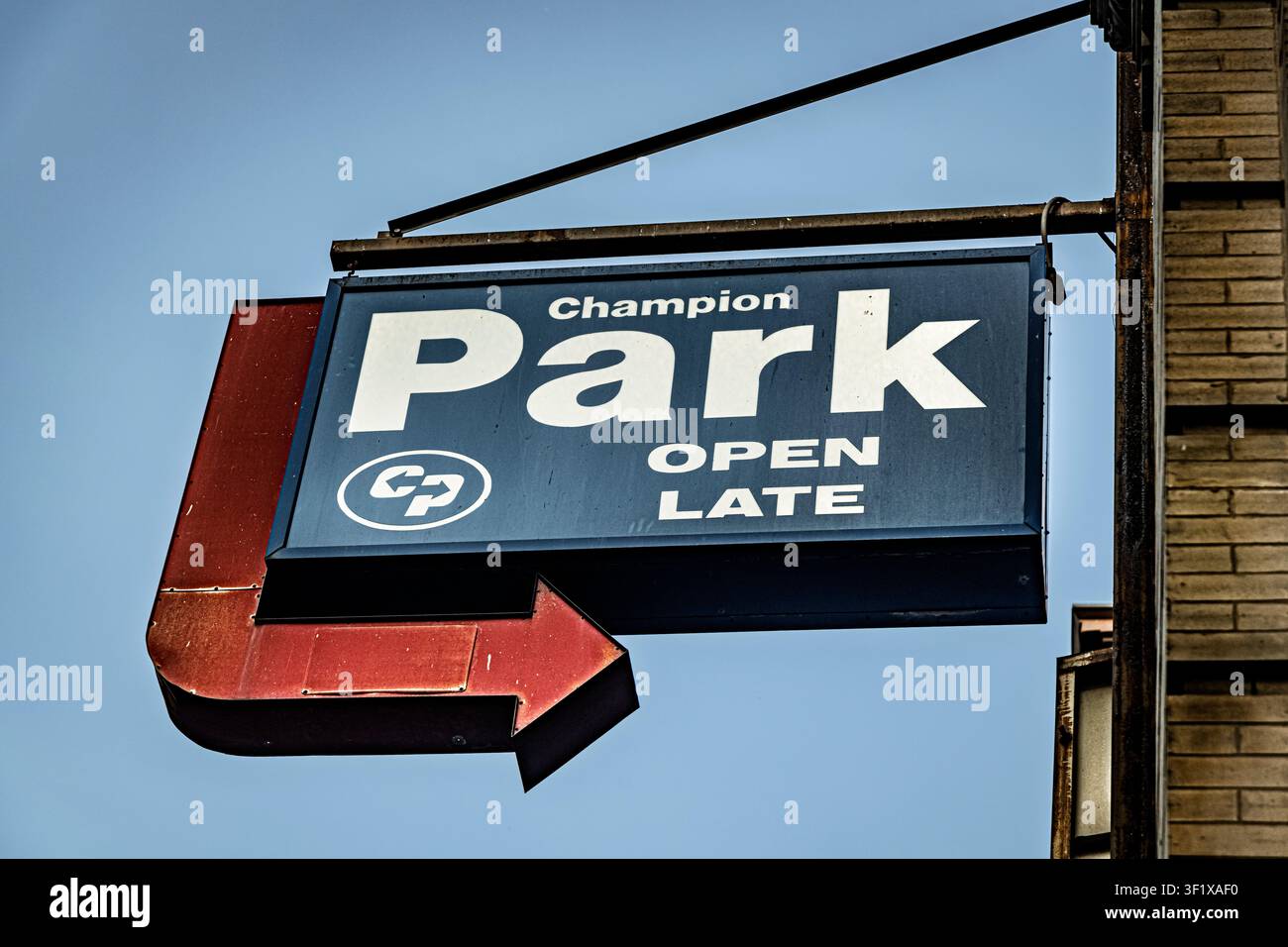 Un cartello blu "Champion Park" con una freccia rossa pubblicizza un parcheggio aperto fino a tardi in una strada di Manhattan. Foto Stock
