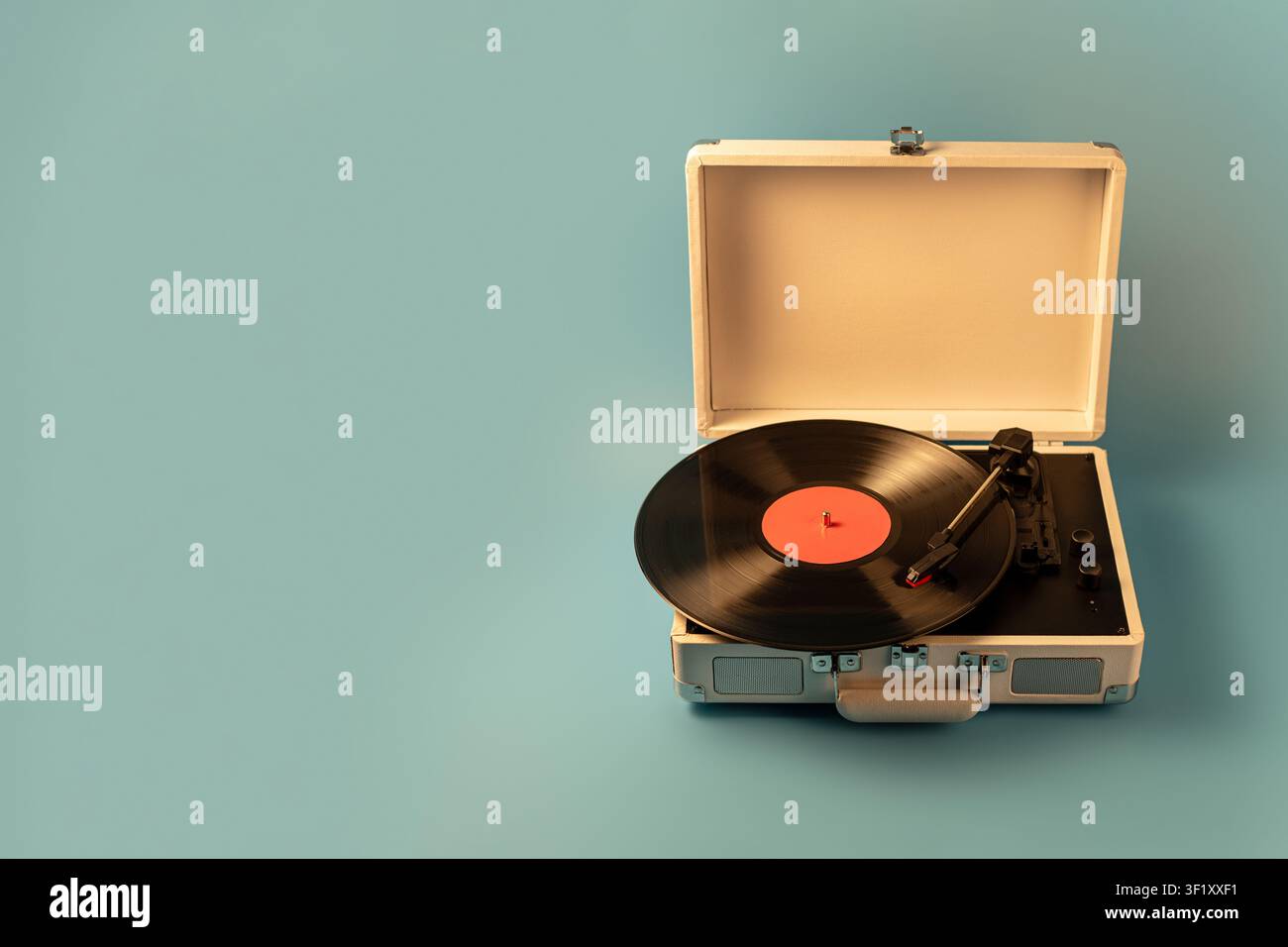 Un giradischi classico è aperto su uno sfondo blu solido, mostrando il suo fascino retrò e le sue capacità audio analogiche Foto Stock