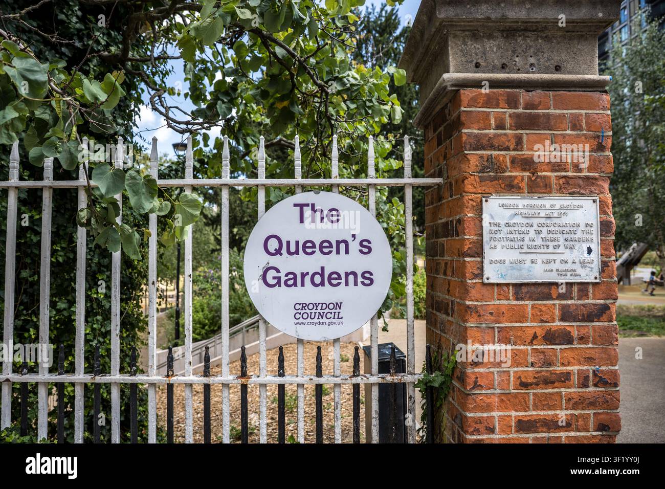 Prima piano del cartello d'ingresso in metallo sul cancello dei Queen's Gardens a Croydon, nel sud di Londra Foto Stock