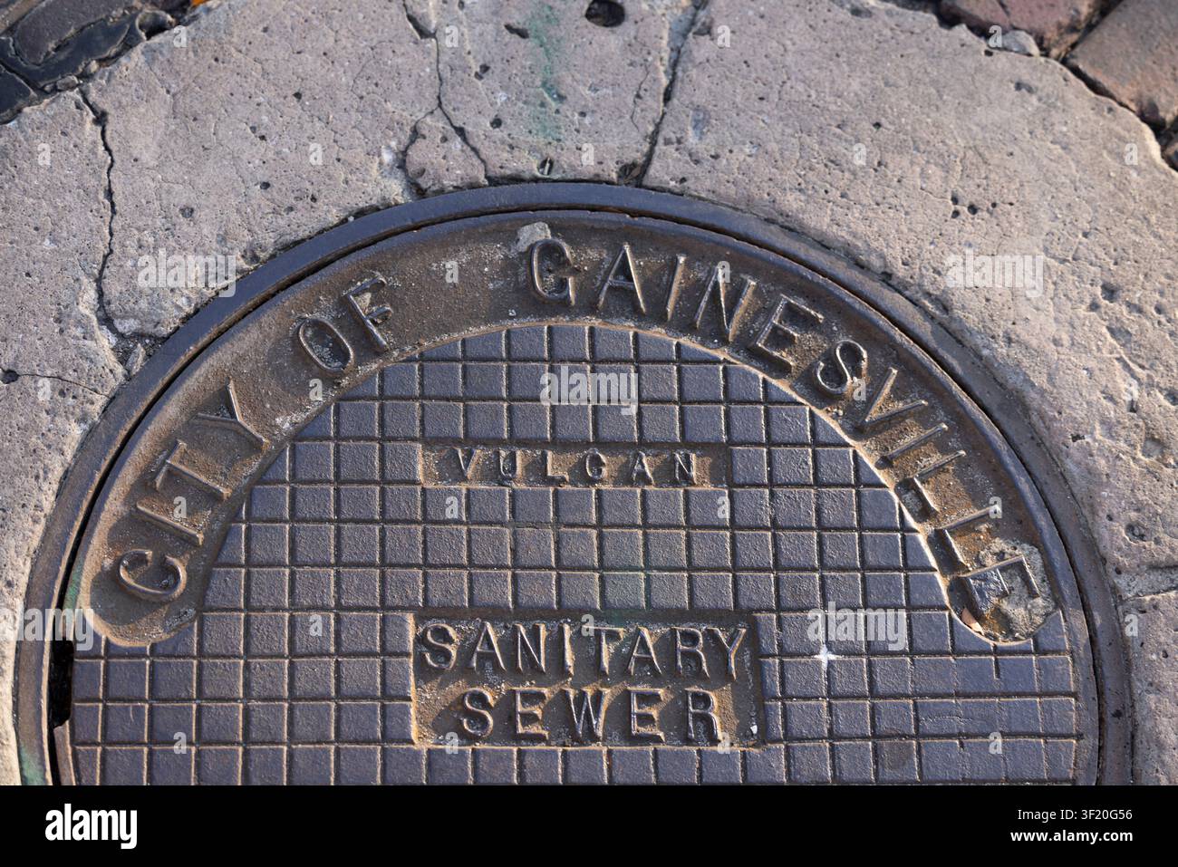 Gainesville, Florida, USA - 27 dicembre 2025: Un logo della città di Gainesville decora un coperchio della fogna. Foto Stock