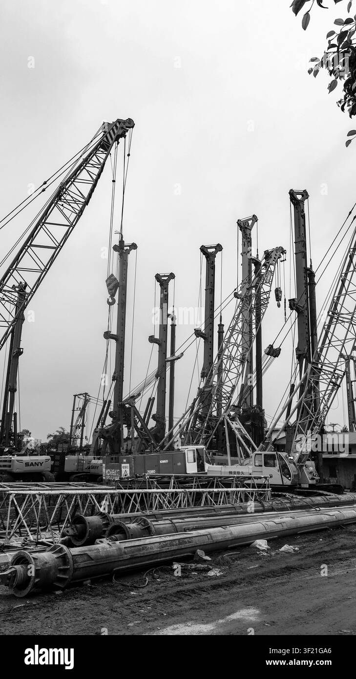 Gru industriali monocromatiche nel cantiere di Hanoi Foto Stock