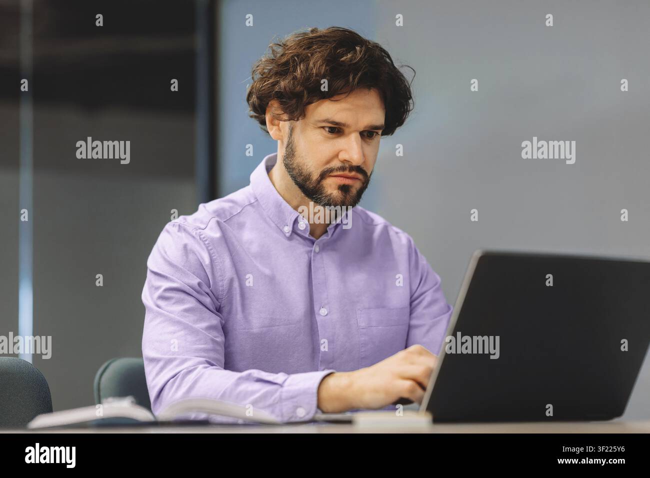 Uomo che lavora su un laptop in ufficio durante il giorno Foto Stock