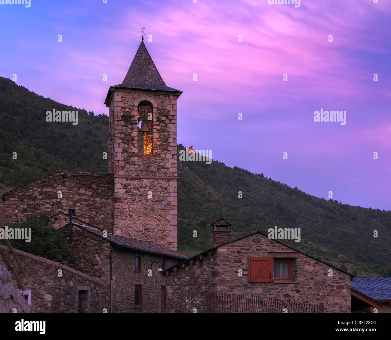 Incastonata a Meranges, la chiesa romanica di Sant Sadurni dell'XI secolo risplende calda al tramonto, mostrando il suo antico fascino di pietra, Catalogna Foto Stock