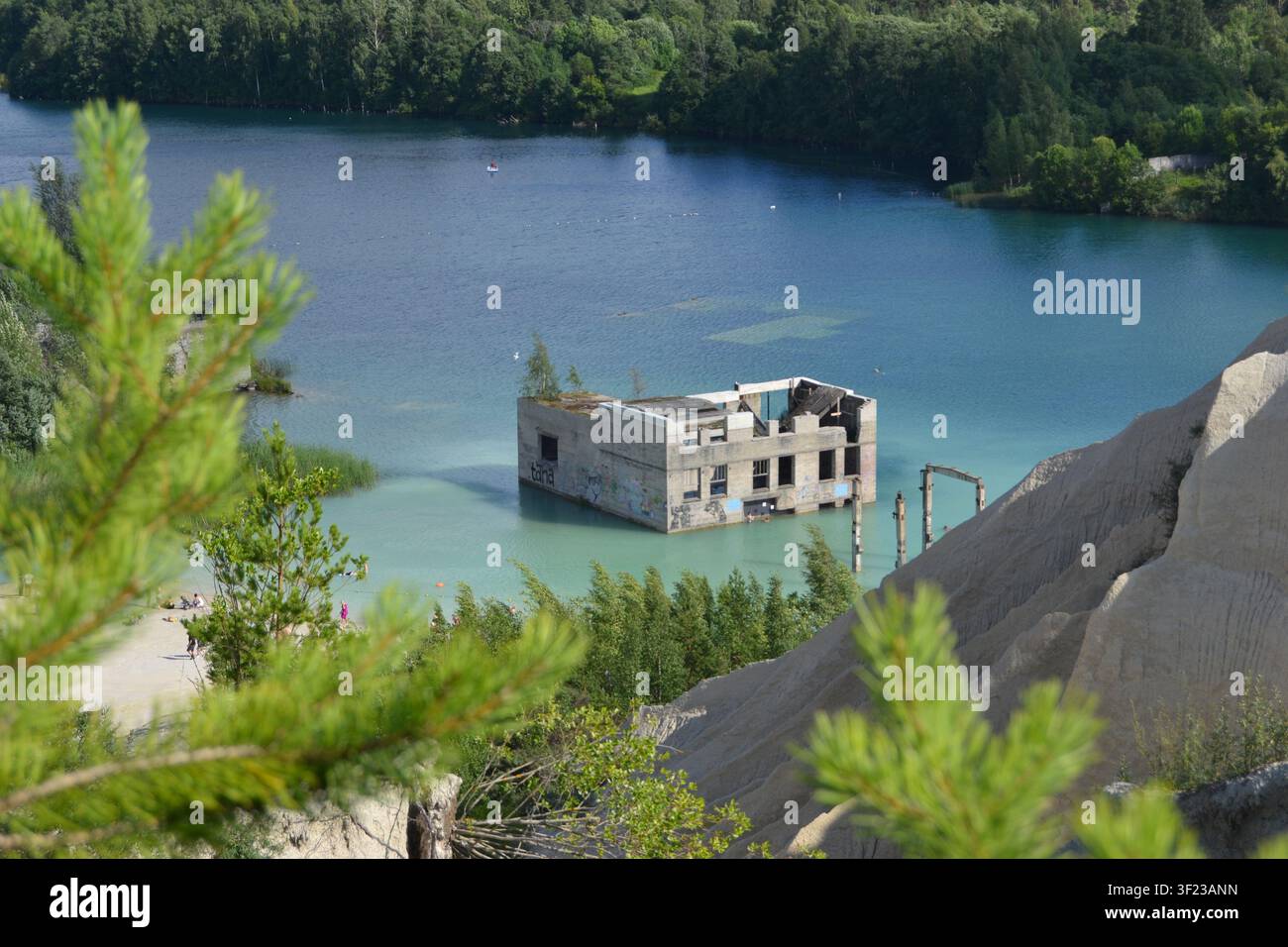 La famosa cava allagata di Rummu, in Estonia, con le rovine di un edificio carcerario precedente parzialmente sommerso in un'acqua turchese straordinaria Foto Stock