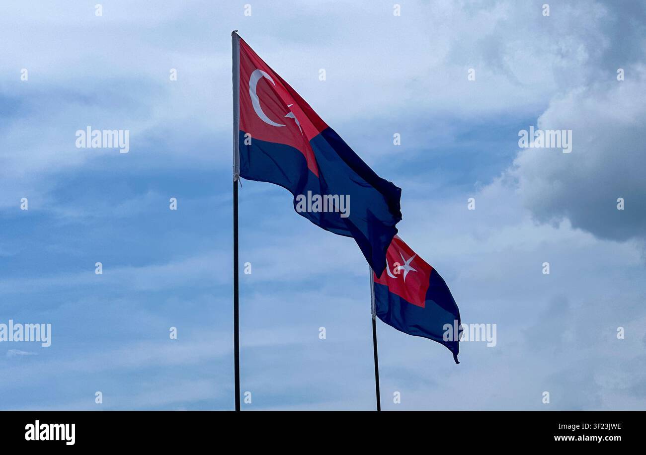 Bandiera dello stato di Johor che sventola contro un cielo nuvoloso a Johor Bahru, Johor, Malesia. - Immagine stock catturata con smartphone