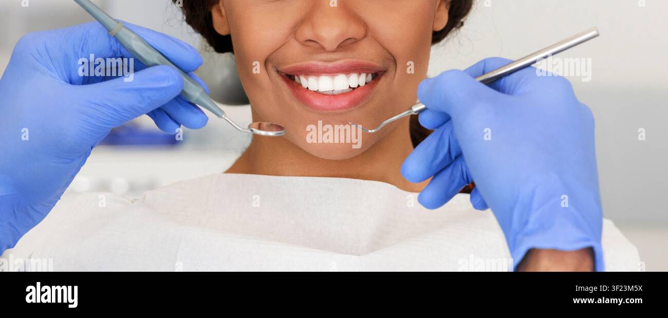 Bella femmina sorriso e mani dentista con strumenti Foto Stock