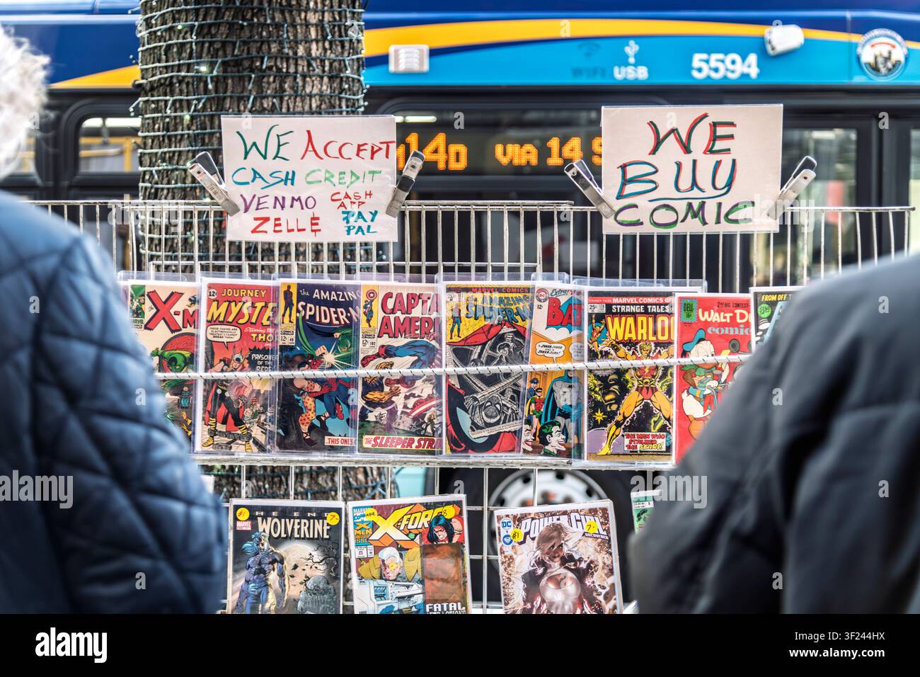 I collezionisti sfogliano scatole di numeri arretrati a una bancarella di fumetti sul marciapiede a New York City. Foto Stock