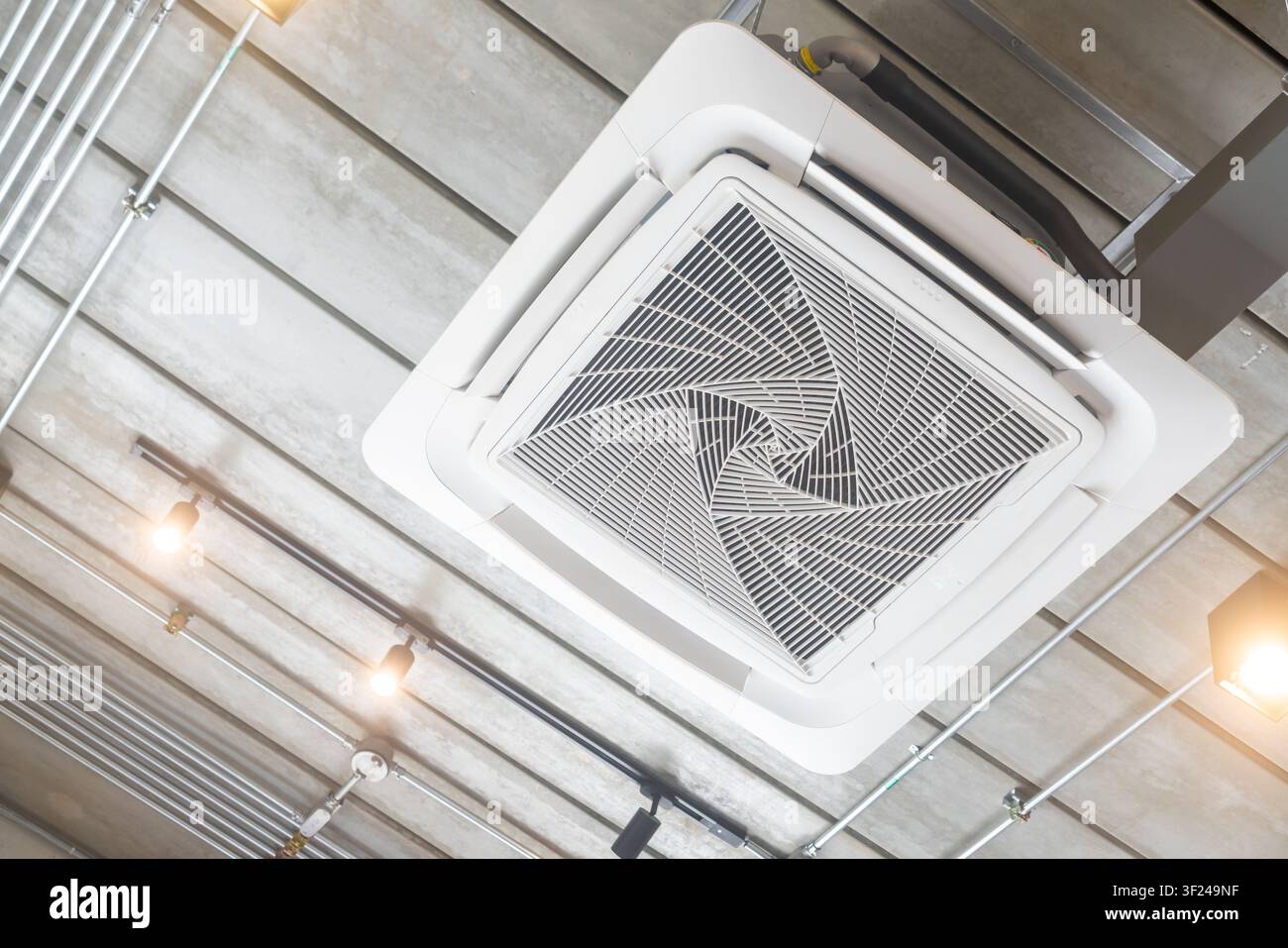 Questa immagine mostra un soffitto sospeso con un condotto di ventilazione moderno montato progettato per l'aria condizionata e il controllo del clima in ambienti commerciali o ind Foto Stock