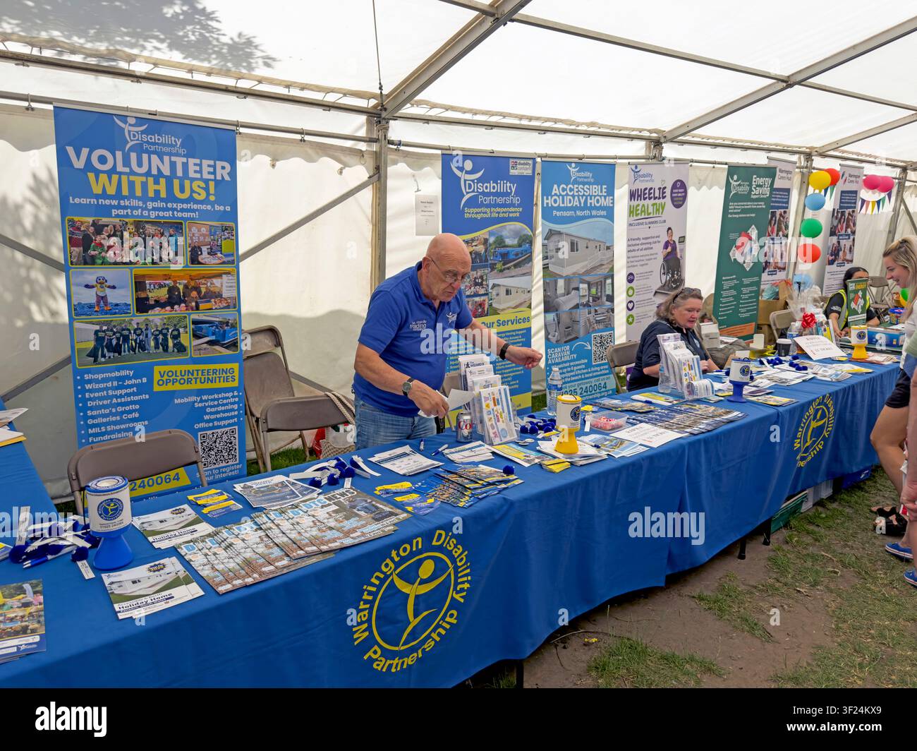 Stand di Warrington Disability Partnership all'interno di un tendone, alla Giornata di sensibilizzazione sul disabile di Warrington nel luglio 2026 Foto Stock