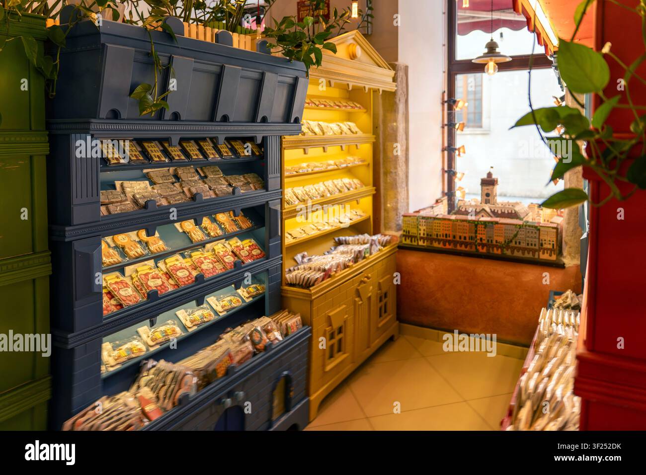 Dentro una pasticceria, scaffali luminosi mostrano diverse dolci e prelibatezze. I clienti si guardano intorno mentre sfogliano le colorate esposizioni. L'atmosfera Foto Stock