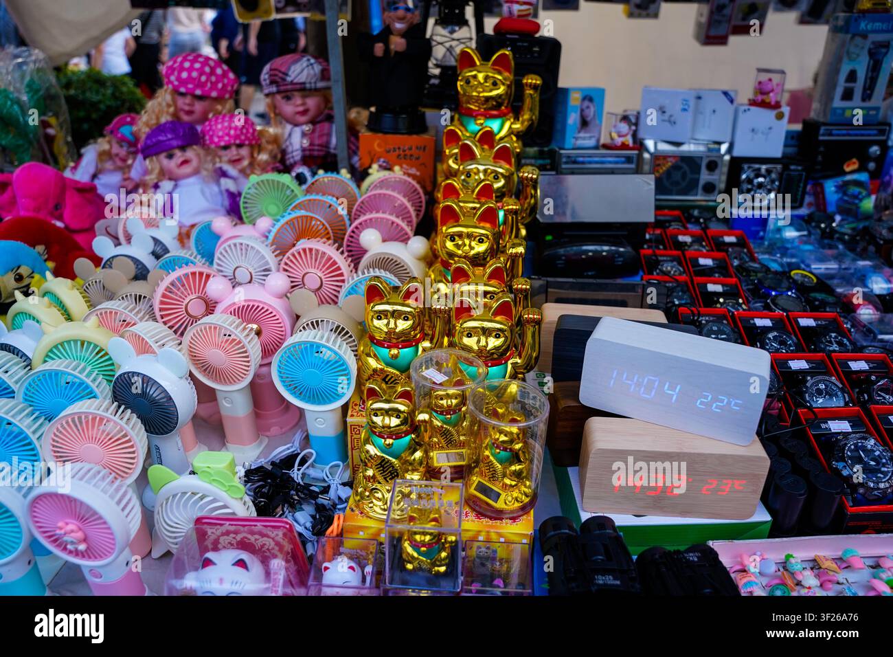 Gatti portafortuna, mini ventole e gadget novelty su una bancarella del mercato ad Atene Foto Stock
