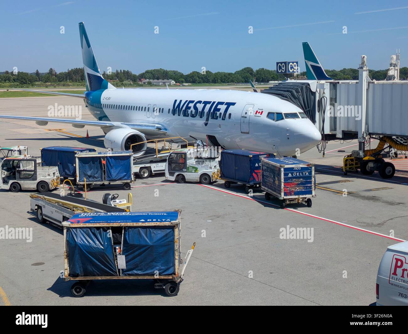 Aereo WestJet sulla pista con la passerella per i passeggeri estesa Foto Stock