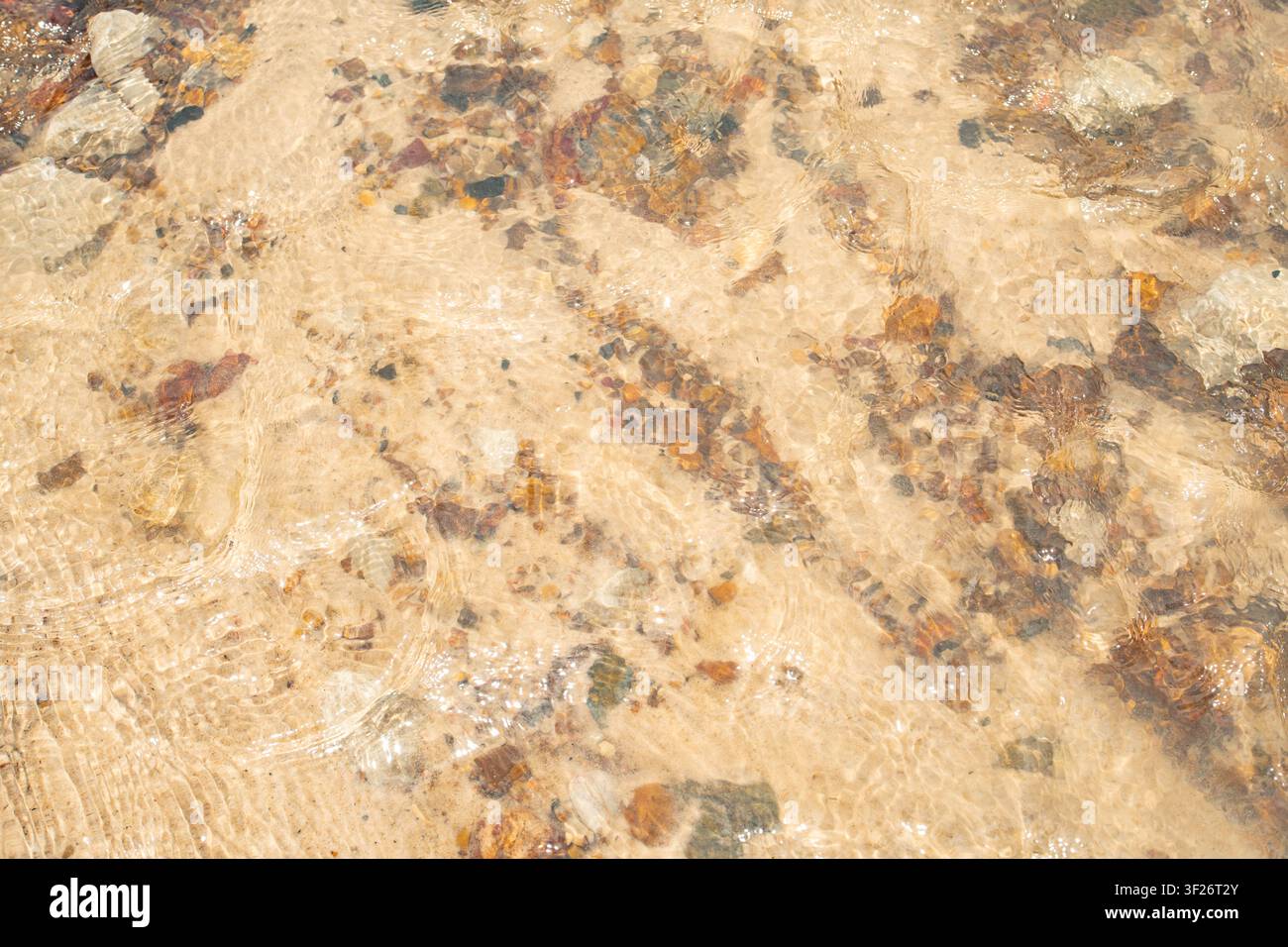 Vista ravvicinata di una superficie di marmo marrone chiaro strutturata con venature naturali e inclusioni minerali. Foto Stock