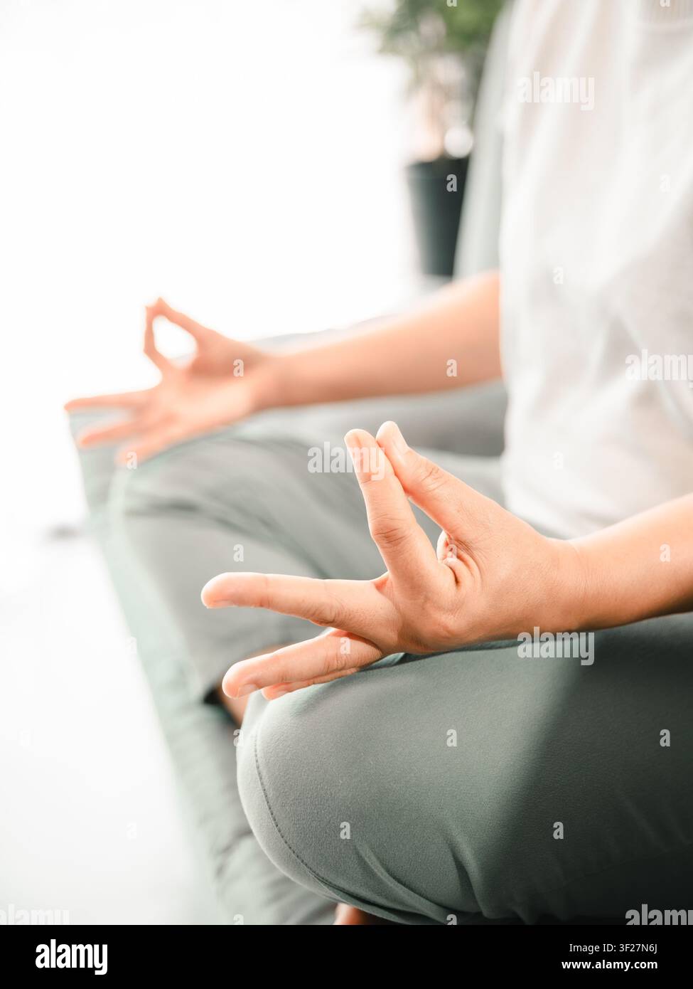 Prima vista delle mani di una donna asiatica in posa mudra di meditazione a casa, concetto di yoga, consapevolezza, respirazione, rilassamento, alleviamento dello stress, benessere e riflessione interiore Foto Stock