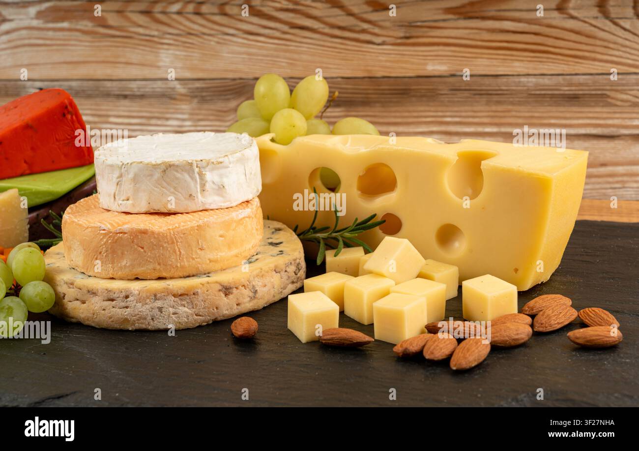 Piatto di formaggi vari colorati, vassoio di gorgonzola giallo, bianco e blu, munster, tavola di formaggi fourme, prodotti caseari tritati assortiti, molti Foto Stock
