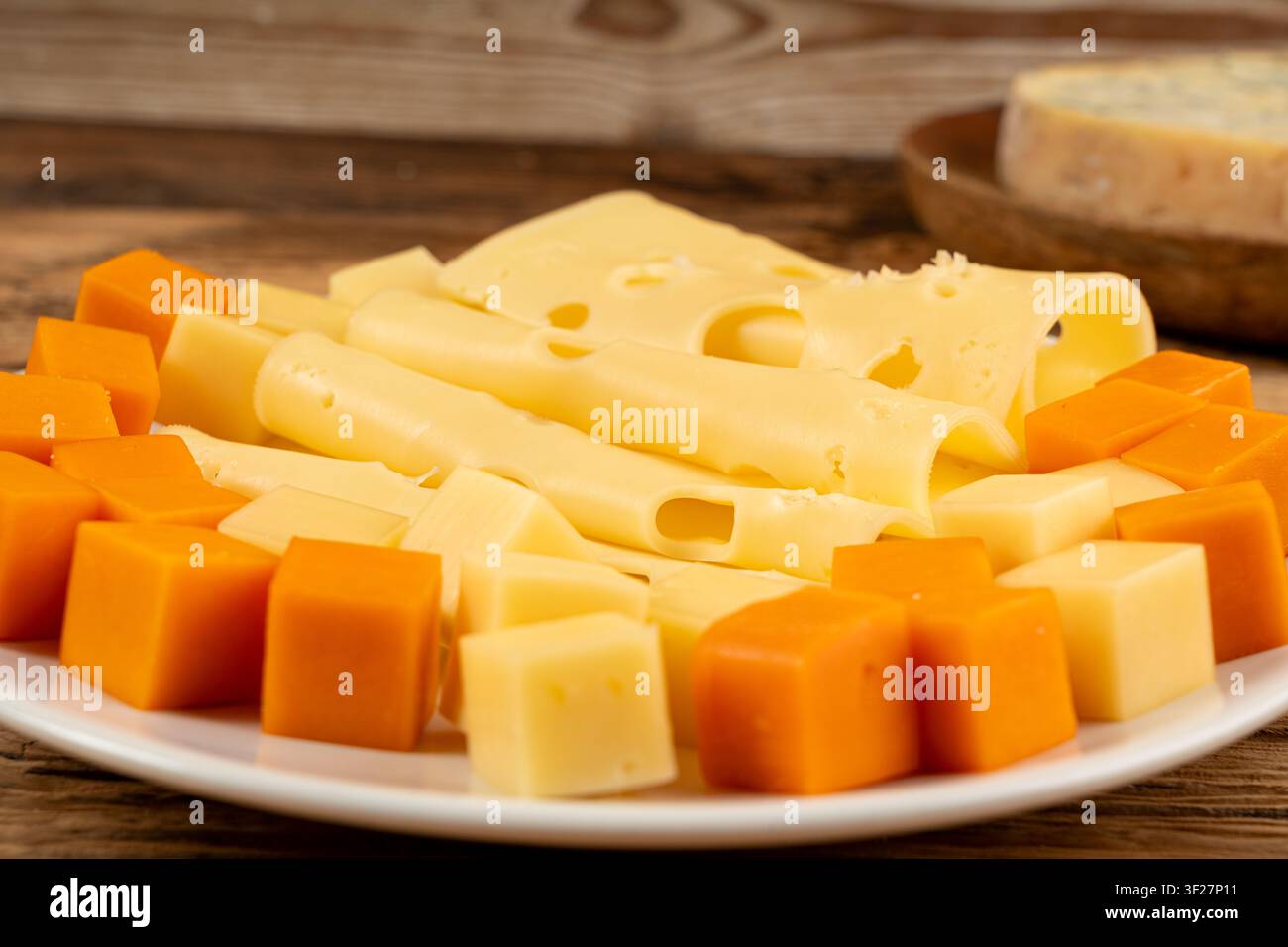Piatto di formaggi vari colorati, vassoio di gorgonzola giallo, bianco e blu, munster, tavola di formaggi fourme, prodotti caseari tritati assortiti, molti Foto Stock