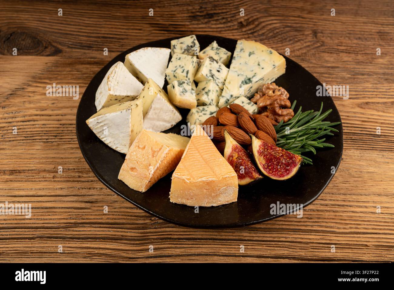 Piatto di formaggi vari colorati, vassoio di gorgonzola giallo, bianco e blu, munster, tavola di formaggi fourme, prodotti caseari tritati assortiti, molti Foto Stock